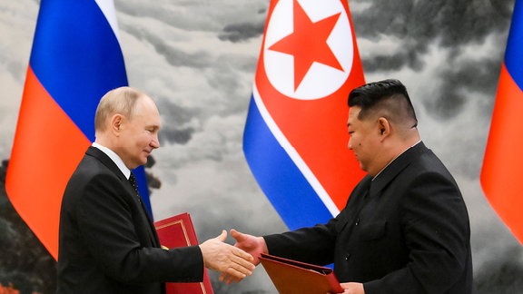 Der russische Präsident Vladimir Putin und Nord Koreas Staatsoberhaupt Kim Jong Un geben sich die Hände.