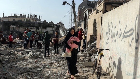 Palästinenser inspizieren beschädigte Häuser, nachdem israelische Kampfflugzeuge ein Haus bombardiert hatten. 