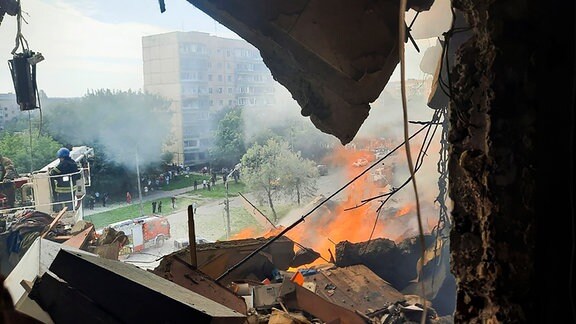 Auf diesem Foto, das von der Pressestelle des ukrainischen Innenministeriums zur Verfügung gestellt wurde, arbeiten Rettungskräfte an einem Ort, nachdem eine Rakete in ein mehrstöckiges Wohnhaus eingeschlagen ist.