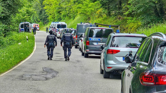 Beamte der Polizei sind bei einer Durchsuchung eines Grundstücks am Ortsrand von Althengstett in Baden-Württemberg im Einsatz. 
