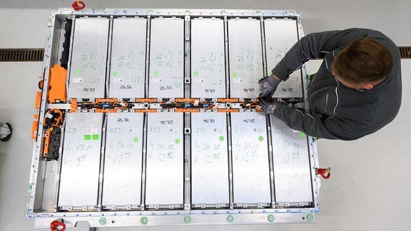 Ein Mitarbeiter entnimmt Batteriemodule aus einer ausgedienten Batterie eines Elektroautos im Batterie-Recycling im VW-Werk Salzgitter. 