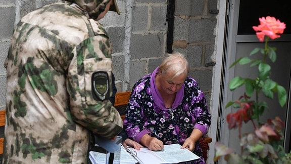 Eine Bewohnerin füllt bei einer mobilen Wahl in Donezk einen Wahlzettel aus.