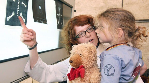Medizinstudentin Rebekka Götz (8.Sem.) erklärt Carlotta das Röntgenbild ihres Teddys. 