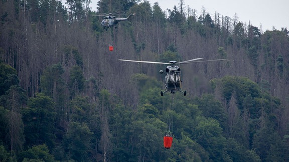 Hubschrauber des tschechischen Militärs löschen Waldbrand aus der Luft