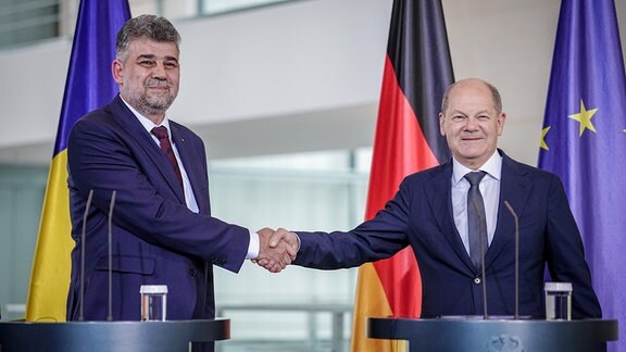 Bundeskanzler Olaf Scholz und Ion-Marcel Ciolacu (l), Ministerpräsident von Rumänien, geben sich die Hände