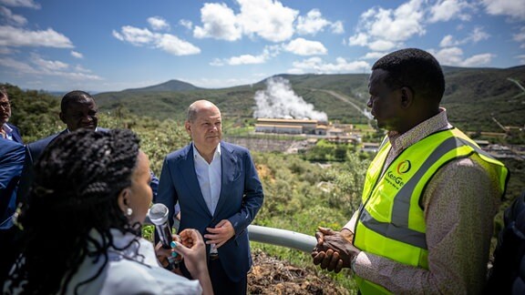 Bundeskanzler Olaf Scholz (SPD, M), besucht die größte Geothermie-Anlage Afrikas in Olkaria am Naivsha-See zusammen mit Davies Chirchir (r), Minister für Energie in Kenia, und lässt sich von Geophysikerin Anna Mwangi das Kraftwerk erklären.