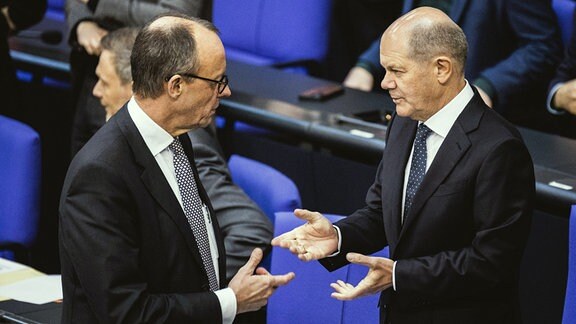 Olaf Scholz SPD, Bundeskanzler, und Friedrich Merz, CDU-Parteivorsitzender, im Bundestage im Gespräch miteinander