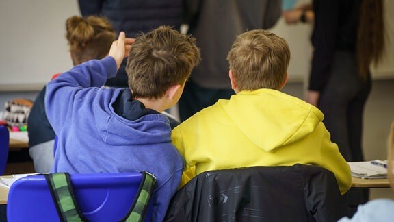 Zwei aus der Ukraine geflüchtete Schüler sitzen an einem Tisch.