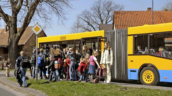 Schüler entsteigen einem Schulbus