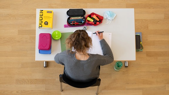 Eine Schülerin sitzt während der Abiturprüfung im Fach Biologieauf ihrem Platz.