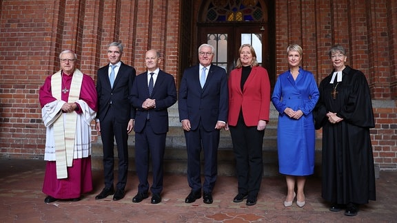 Erzbischof Heiner Koch (l-r), Bundesverfassungsgerichtspräsident Stephan Harbarth, Olaf Scholz (SPD), Bundespräsident Fank-Walter Steinmeier, Bundestagspräsidentin Bärbel Bas (SPD), Manuela Schwesig (SPD), Ministerpräsidentin von Mecklenburg-Vorpommern und derzeitige Bundesratspräsidentin, und Landesbischöfin Kristina Kühnbaum-Schmidt, vor dem vor dem Schweriner Dom stehend.