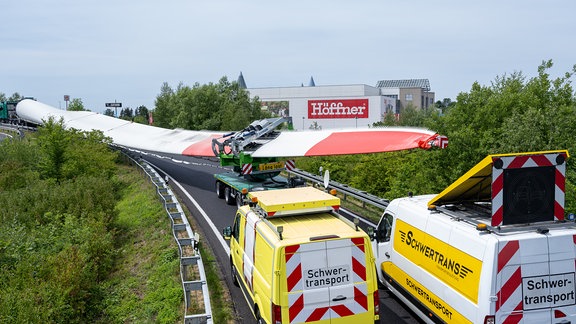 Ein Schwerlasttransport mit drei LKW und aufgeladenen Flügeln für eine Windkraftanlage steht in der Abfahrt Chemnitz Mitte der Autobahn 4.