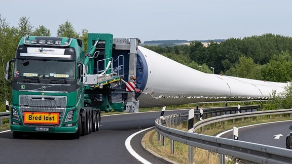 Ein Schwerlasttransport mit drei LKW und aufgeladenen Flügeln für eine Windkraftanlage steht in der Abfahrt Chemnitz Mitte der Autobahn 4.