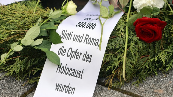 Ein Kranz mit der Schleifen-Aufschrift "Gedenken an die 500.000 Sinti und Roma, die Opfer des Holocaust wurden", aufgenommen bei der Gedenkveranstaltung zum 78. Tag der Befreiung des Konzentrationslagers Mittelbau-Dora. 