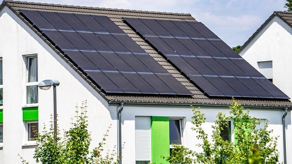 Solarpanele auf dem Spitzdach eines Wohnhauses
