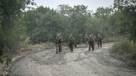 Soldaten gehen einen Weg entlang.