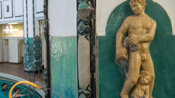Figuren in Badeszenerie zieren die Säulen in der Frauenhalle des Stadtbades in Halle/Saale (Sachsen-Anhalt)