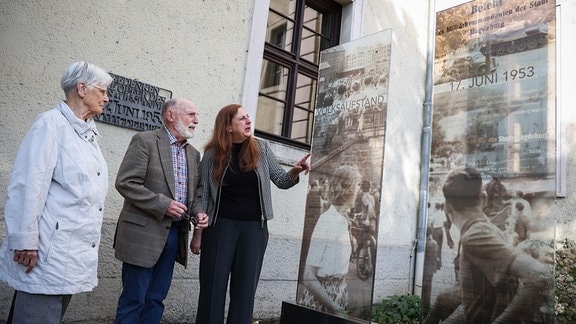 Die Künstlerin Christine Bergmann (r-l) steht mit den Zeitzeugen Johannes Rink und Ursula Wolf vor dem Gebäude des heutigen Innenministeriums in Magdeburg neben zwei Glasstelen, die an den Volksaufstand in der ehemaligen DDR, am 17. Juni 1953, erinnern.