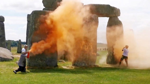 Das Videostandbild zeigt Demonstranten von «Just Stop Oil», die eine orangefarbene Substanz auf Stonehenge sprühen.