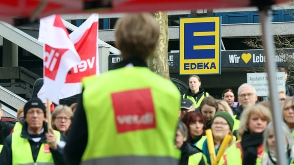 Während eines Warnstreiks im Einzelhandel stehen Mitarbeiter bei einer Kundgebung vor der Edeka-Zentrale in Hamburg. 