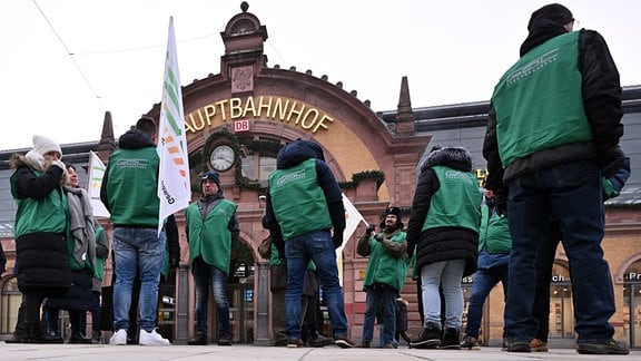Mitglieder der Lokführergewerkschaft GDL stehen mit Fahnen vor dem Erfurter Hauptbahnhof. 