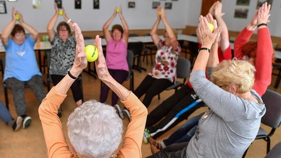 Unter Anleitung eines Übungsleiters trainieren  2017 Seniorinnen mit einem Tennisbällen.