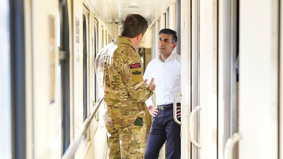 Der britische Premierminister Rishi Sunak (rechts) spricht mit dem stellvertretenden Chef des Verteidigungsstabs, Generalmajor Gwyn Jenkins, in einem Zug, der durch die Ukraine fährt.