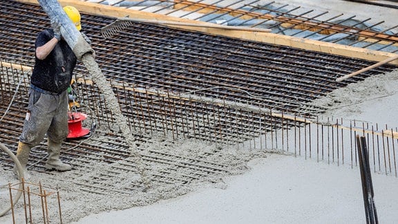 Flüssiger Beton für eine Bodenplatte eines Rohbaus für Eigentumswohnungen im Stadtteil Ehrenfeld wird in eine Stahlkonstruktion gefüllt. 