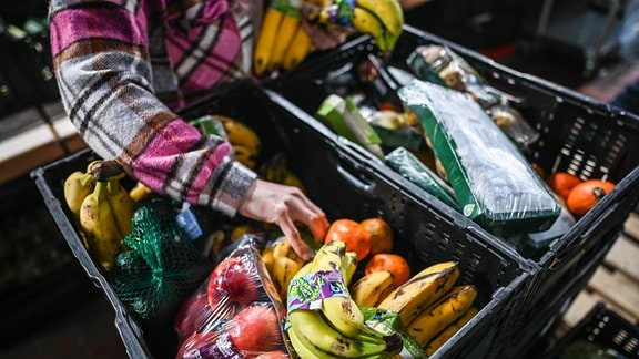 Eine Helferin sortiert in Supermärkten aussortierte Lebensmittel bei der Tafel 