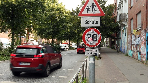 Ein Verkehrsschild in einer Nebenstraße weist Verkehrsteilnehmer darauf hin, dass hier werktags von 6 bis 22 Uhr nur Tempo 30 erlaubt ist.