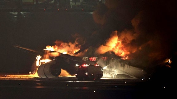 Brennendes Flugzeug nach Kollision auf Flughafen Tokio-Haneda