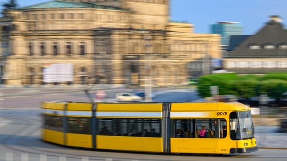 Eine Straßenbahn der Dresdner Verkehrsbetriebe (DVB) fährt in der Altstadt über den Theaterplatz an der Semperoper entlang. 