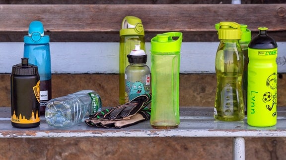 Trinkflaschen stehen beim Fußball Sommer Camp des Dresdner Vereins SC Borea Dresden auf einer Bank.
