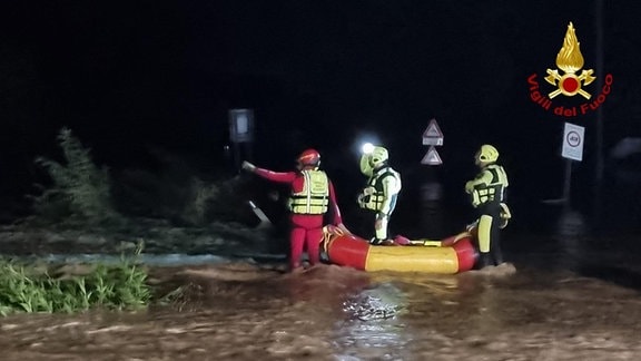 Einsatzkräfte mit Schlauchbott bei Nacht