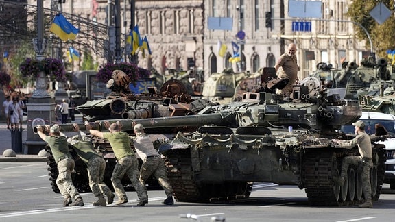 Soldaten bereiten eine Ausstellung mit erbeuteten russischen Panzern auf einer Straße in Kiew vor, während sich die Ukrainer auf den Unabhängigkeitstag vorbereiten. 