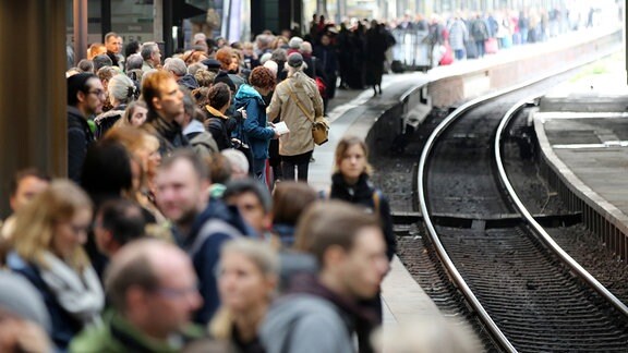 Reisende warten im Hauptbahnhof in Hamburg auf einen Zug.