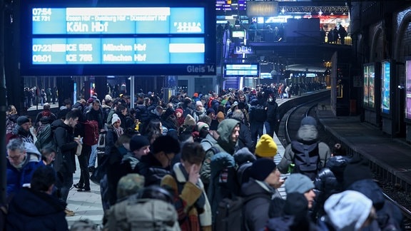 Zahlreiche Reisende warten am Morgen am Hauptbahnhof auf einen Zug.