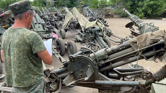 Russische Armeeangehörige erhalten Waffen der Wagner-Einheiten.
