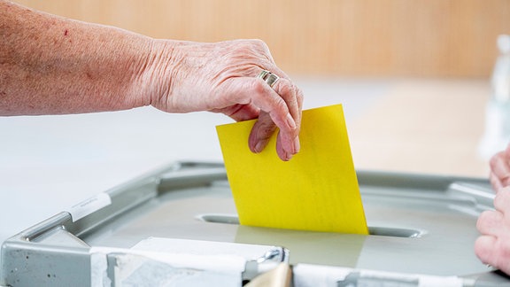 Eine Wählerin wirft ihren Wahlzettel in die Wahlurne