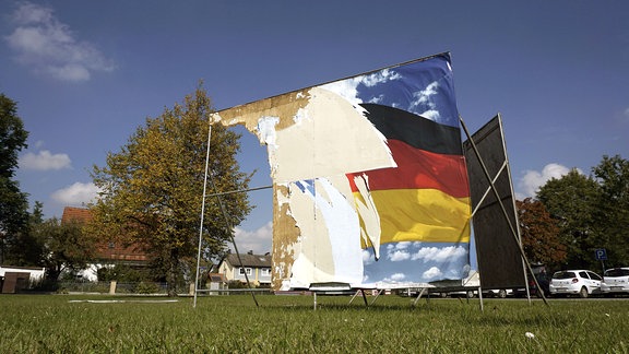Ein Wahlplakat zur Bundestagswahl 2017 ist fast komplett zerstört und heruntergerissen.