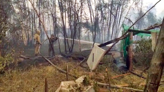 Feuerwehrleute bekämpfen einen Flächenbrand in der Gemeinde Byas-Kyuyol.