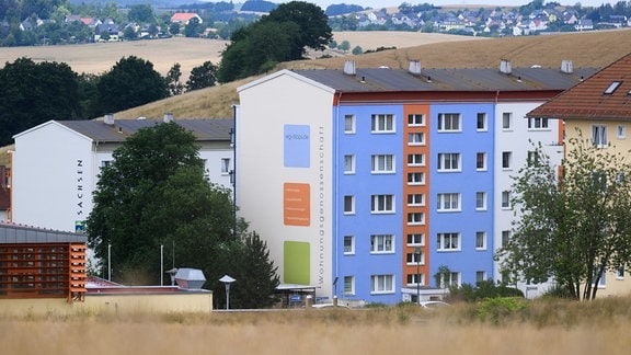 Das Logo der Wohnungsgenossenschaft Dippoldiswalde an der Fassade eines Wohnblocks