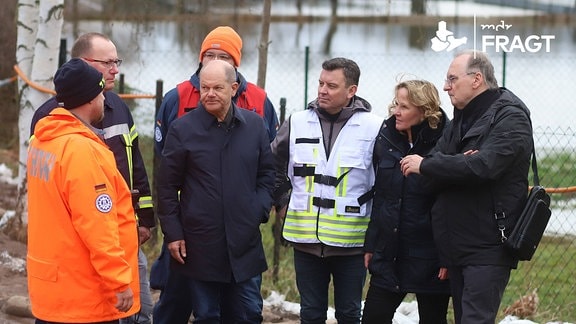 Bundeskanzler Olaf Scholz (SPD) spricht mit Hochwasser-Helfern bei Bewältigung der Hochwasserlage an der Helme im Landkreis Mansfeld-Südharz.