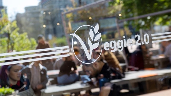  Ein Aufkleber mit der Aufschrift "Veggie 2.0" ist an dem Fenster der veganen Mensa auf dem Campus der Technischen Universität angebracht. 