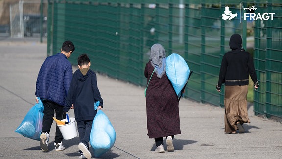 In Plastiksäcken tragen neu angekommene Flüchtlinge ihre Habseligkeiten in der hessischen Erstaufnahmeeinrichtung (HEAE) in Gießen