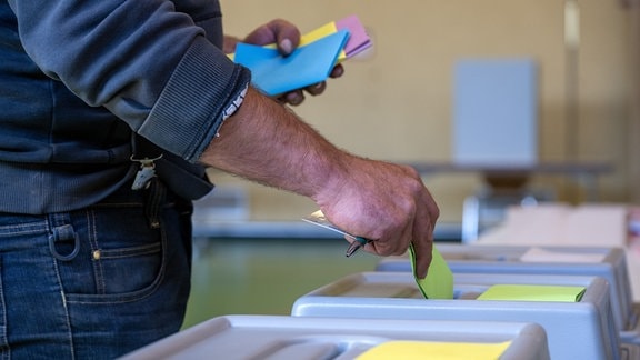 Ein Mann wirft seine Stimzettel in die Wahlurne, um seine Stimmen abzugeben.