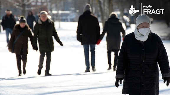 Spaziergänger im verschneiten Park.