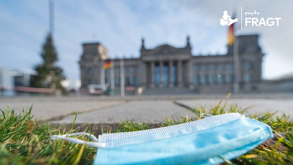 Mund-Nasen-Schutz liegt auf der Wiese vor dem Deutschen Bundestag Berlin
