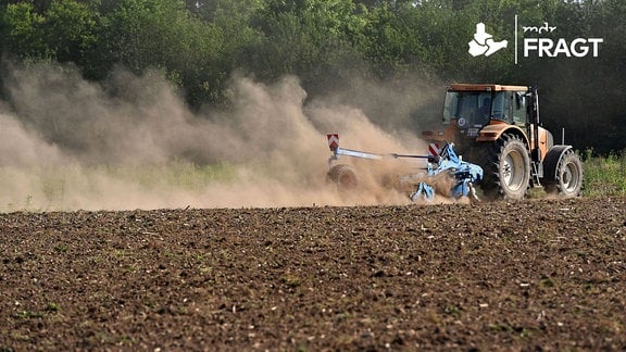 Ein Traktor mit Egge zerkleinert auf einem Acker bei Haar -oestlich von Muenchen-bei anhaltender Trockenheit Erdschollen-es staubt,Staub.