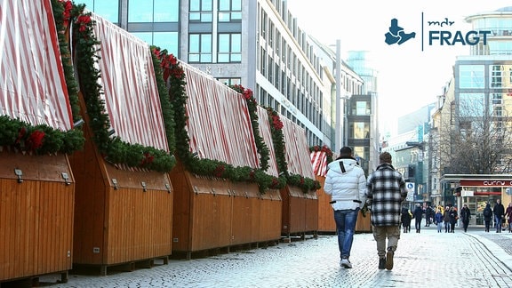 Abbau des Leipziger Weihnachtsmarktes. Passanten gehen an geschlossenen Marktständen vorbei.